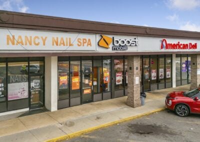 A row of bustling tenants, including Boost Mobile and American Deli, with multiple cars out front at the Akers Center in Gastonia NC