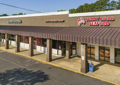 A row of several popular businesses including Yummy Crab Seafood restaurant, Cash's Barber Shop, and Jackson's Cafeteria at the Akers Center in Gastonia NC