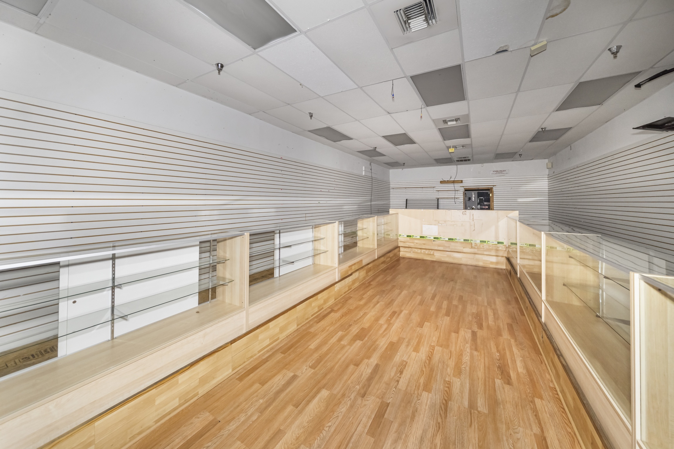 inside suite 3789, a former cellphone store, with display cases and an expensive looking wood floor