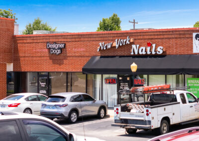 the storefronts for New York Nails and Designer Dogs at Heritage Plaza in Midwest City OK, with a bunch of cars parked in front
