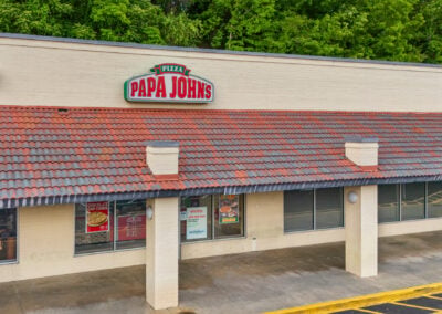 the entrance to Papa John's pizza, with a red and grey tiled awning, at the Marion City Square shopping center in Marion NC
