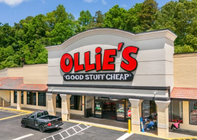the bright storefront of the new Ollie's Bargain Outlet at Marion City Square, with a backdrop of green trees
