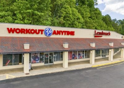 curved storefronts of Workout Anytime and Lendmark, with others trailing into the distance, at Marion City Square