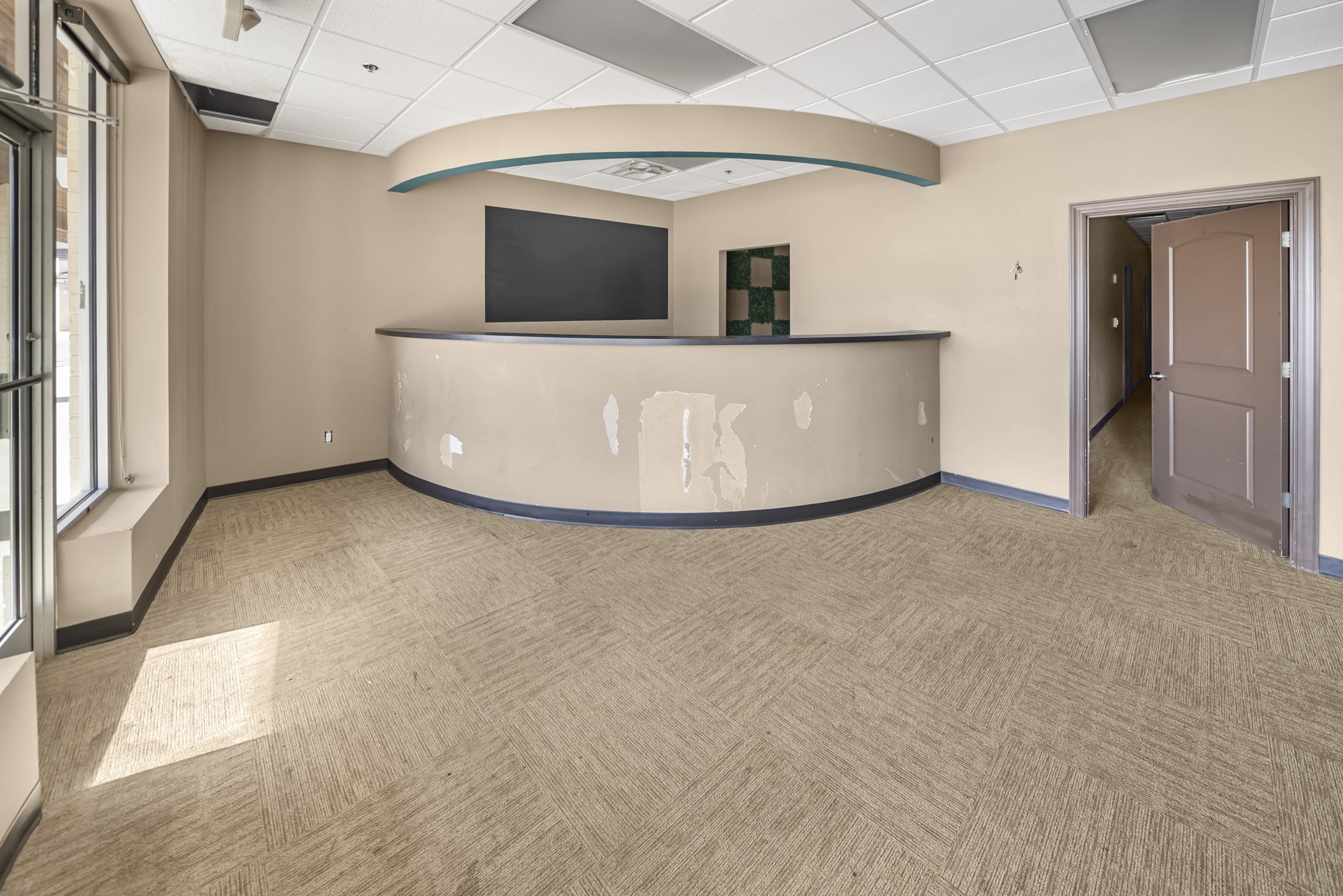front reception desk and waiting room with brown carpet and tan walls, at the entrance to suite 16, a 2,800 SF Office Suite in Marion City Square, now available for lease