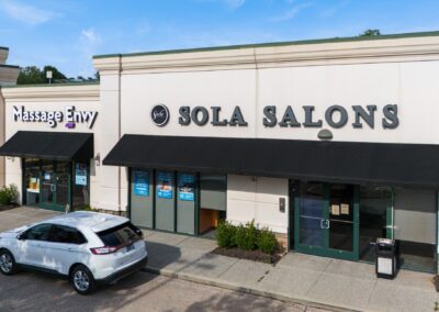 Sola Salons and Massage Envy storefronts with a car out front, in Cordova TN