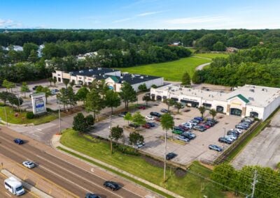 aerial view of the Shops at Rock Creek in Cordova TN, with trees in the parking lot and lots of cars passing it on the main road.