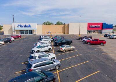 the Lyon Plaza shopping center viewed from the parking lot full of cars, with the new Marshalls and the Harbor Freight Tools, in Marshall MN
